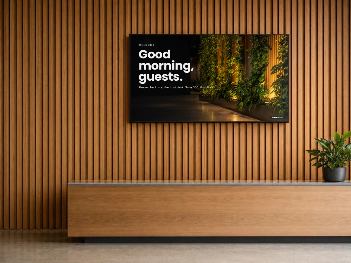 A screen behind an office reception desk welcoming guests