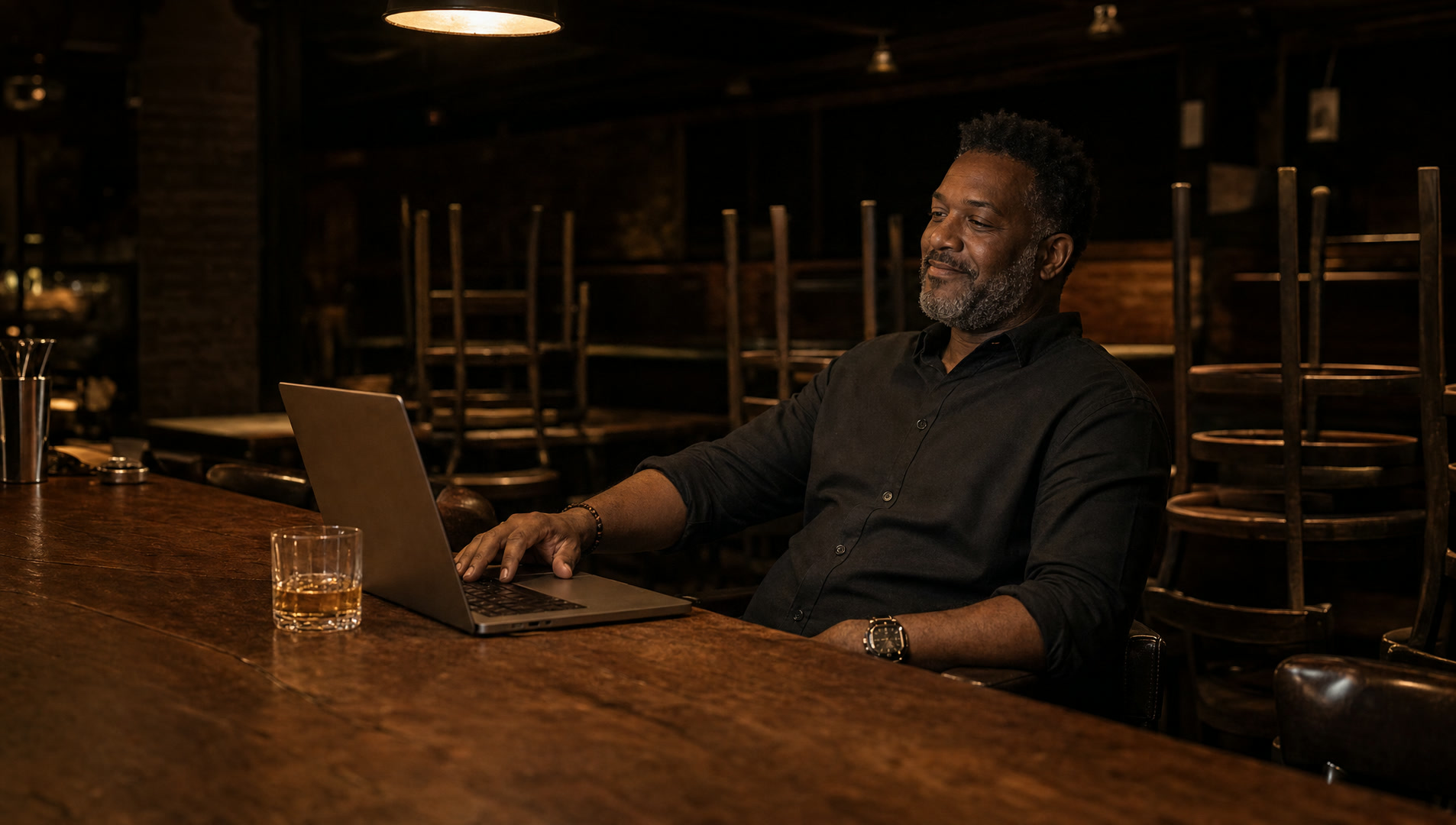 An owner at the bar after close with a laptop